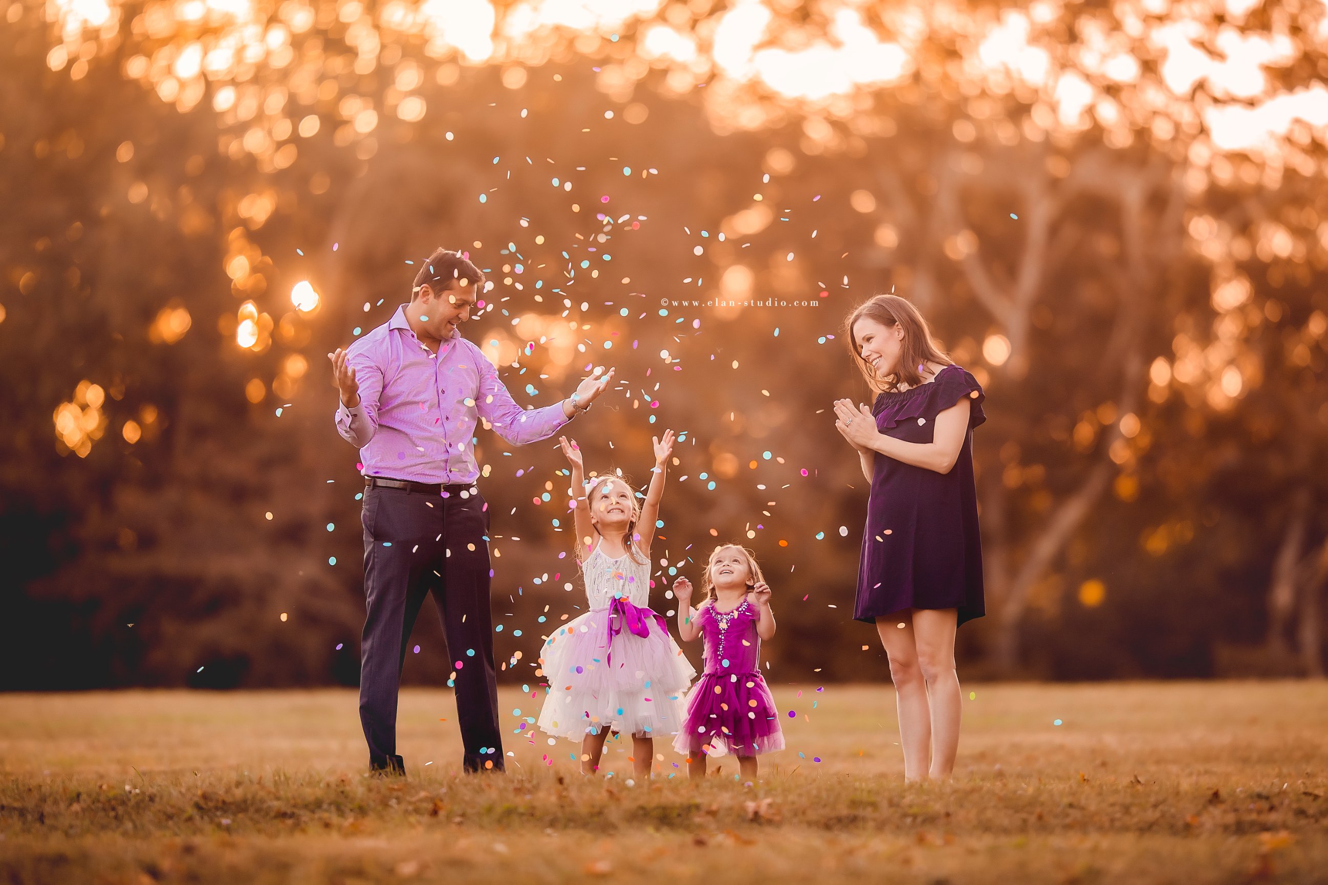 parents with two little girls throwing confetti