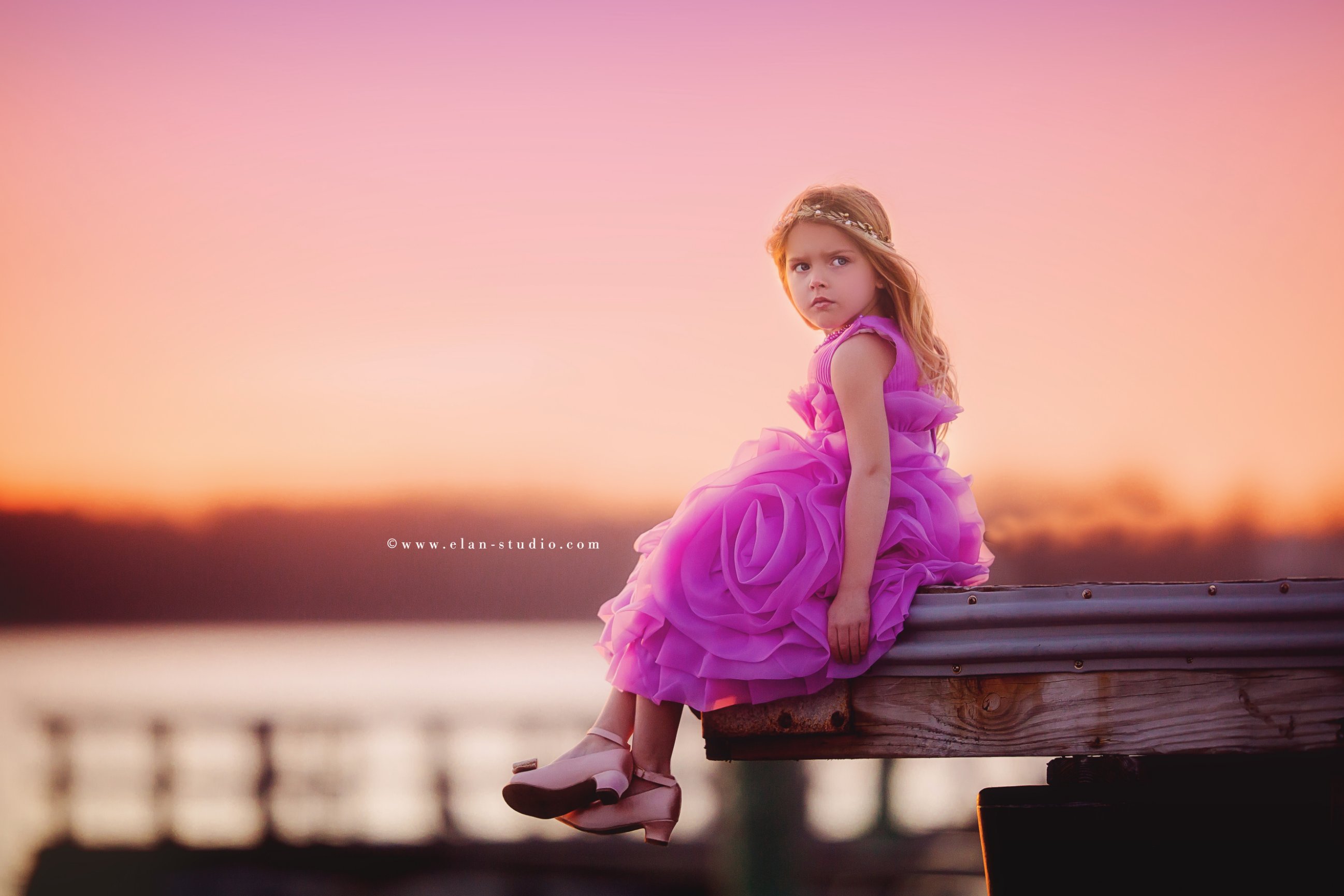 little blonde girl wearing rose chiffon dress and petal colored shoes at sunset