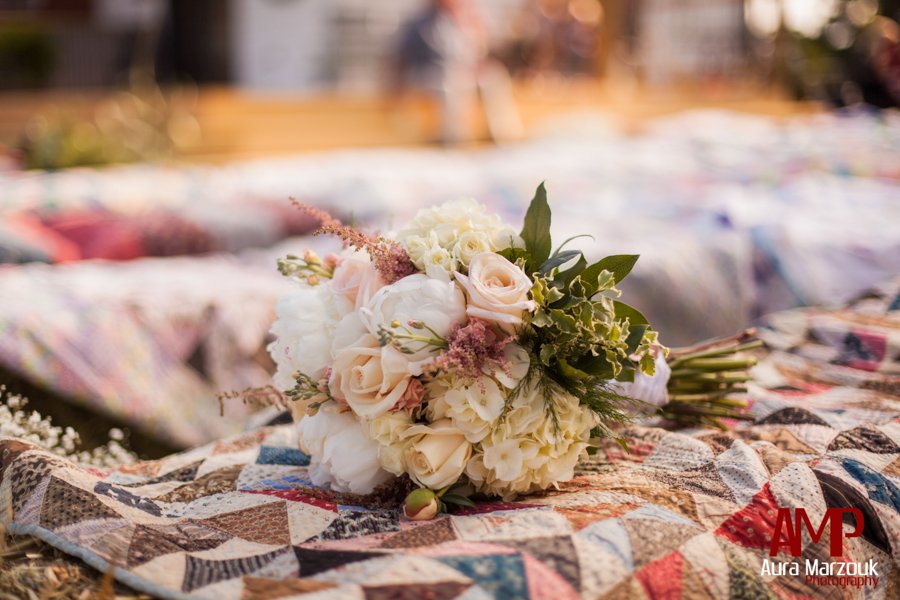 Grandmother's antique quilt covers the hay bales at this rustic Seagrove DIY wedding.