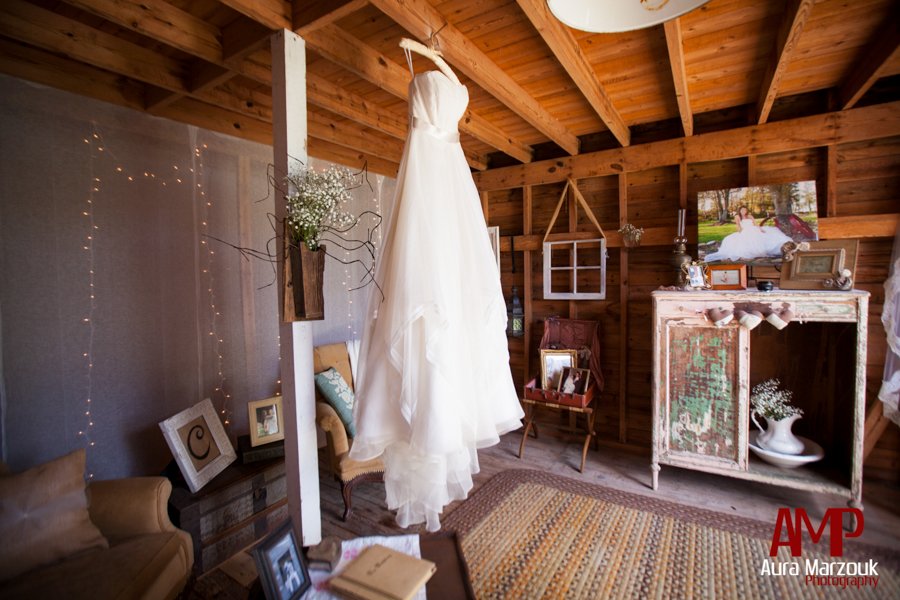 Sara's beautiful ivory gown looks beautiful inside this rustic barn in Seagrove, NC. © Aura Marzouk Photography