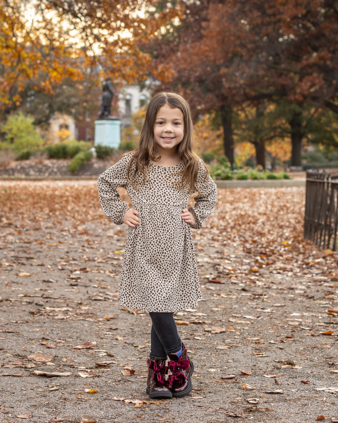 Child standing in autumn leaves
