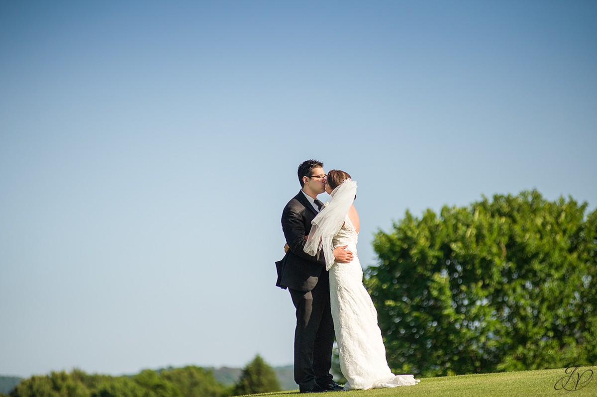 bride and groom kissing golf course photo