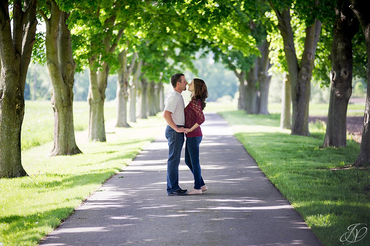 romantic couple kissing in row of trees
