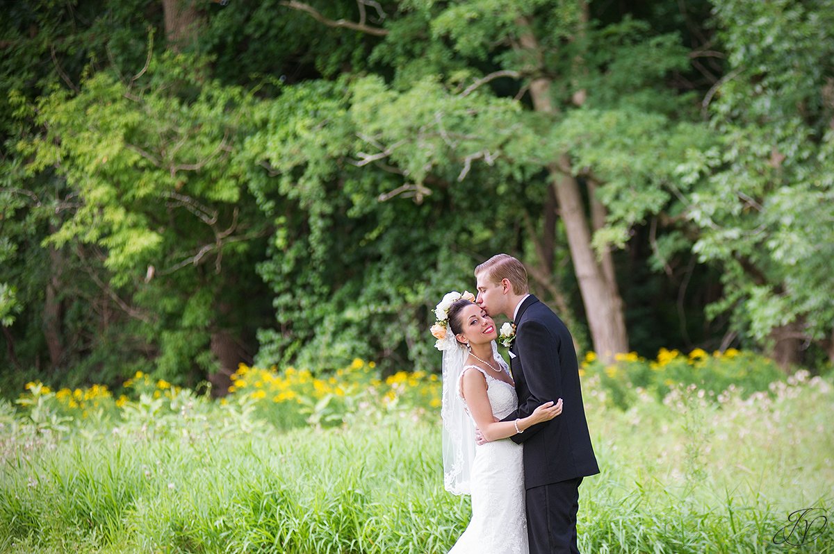 groom kissing bride on forehead normanside country club