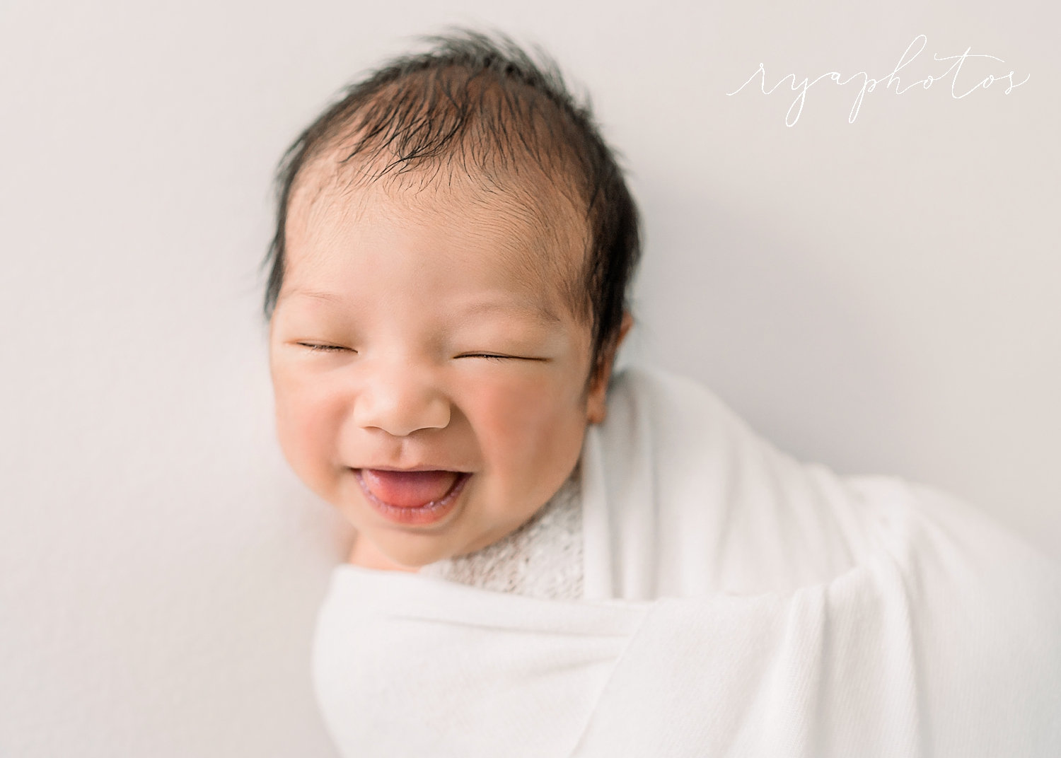 smiling newborn baby with dark hair, studio newborn session, Rya Duncklee