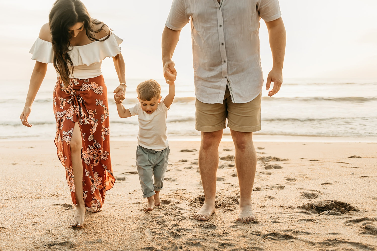 family walking on the beach with their young son at sunrise, Rya Duncklee Photography