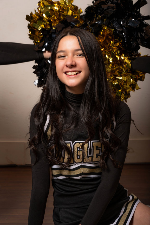cheerleader casually sitting on the ground in uniform