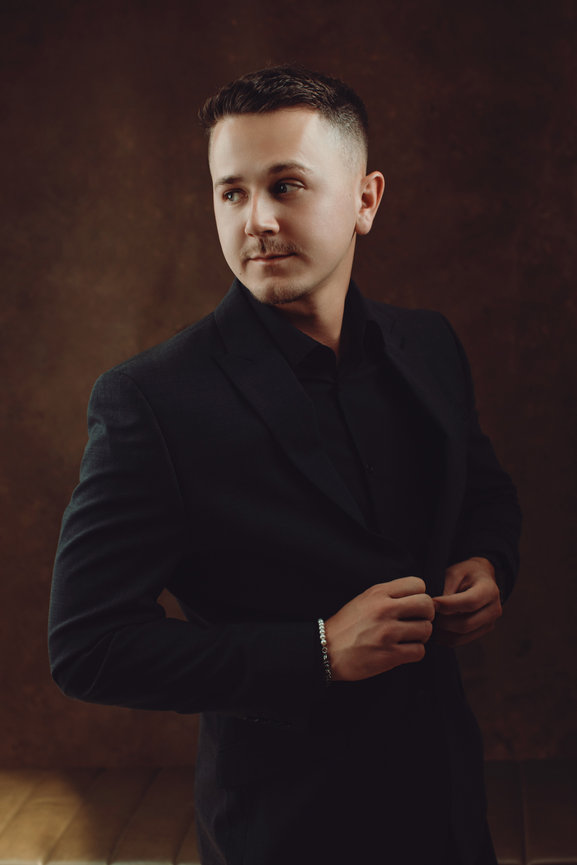 Strong male portraits professionally taken in studio while wearing an all black suit, taken in a photo studio with Adam Trujillo, a Las Vegas portrait photographer.