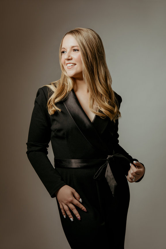 Studio portrait with woman in black jumper and warm white backdrop, taken in a photo studio with Adam Trujillo, a Las Vegas portrait photographer.