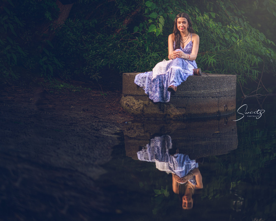 Senior in lavender dress reflected in water, fine art conceptual portrait by Swartz Portraits Texas