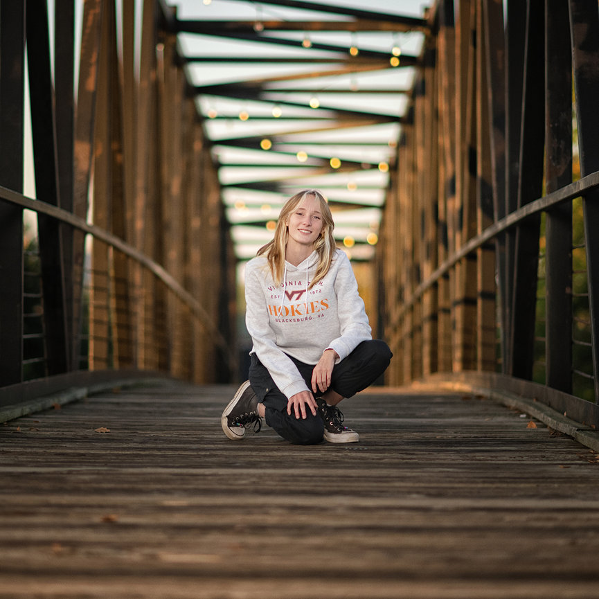 Senior portrait at Hughes Landing Woodlands Waterway walking bridge bistro lights by Master Photographer Ty Swartz