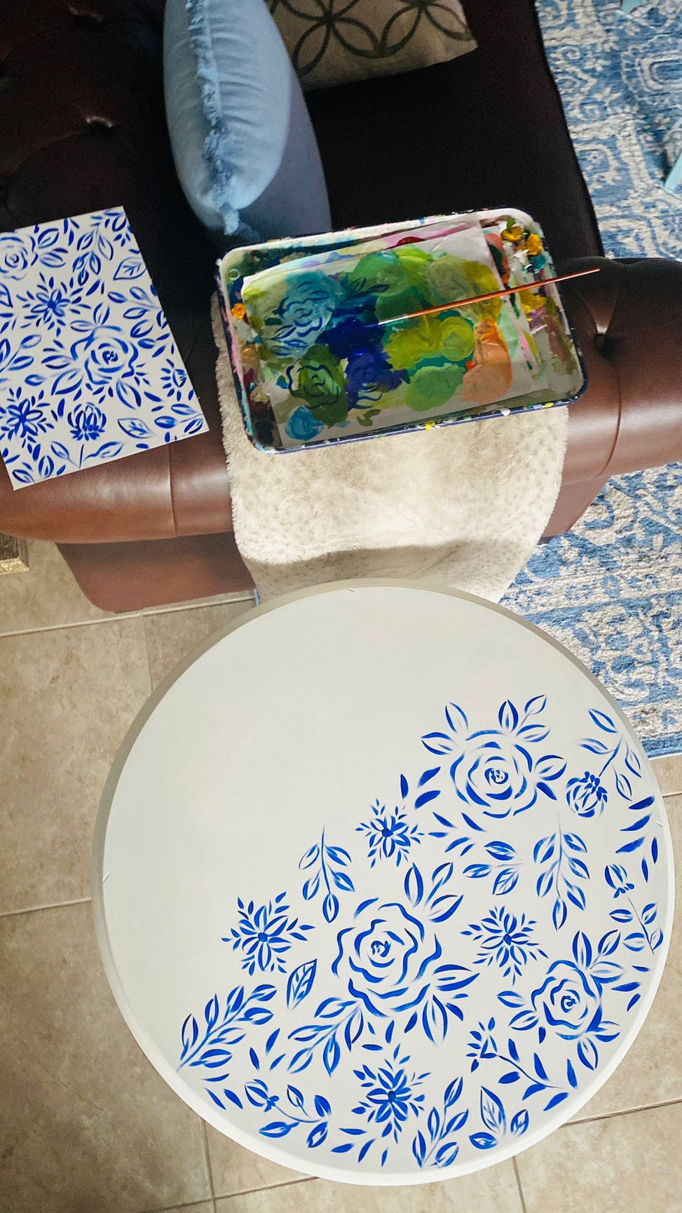 hand painting a wood table as an upcycle project with flower design