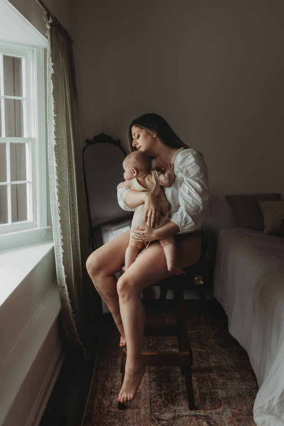 A woman sitting on a stool with her baby in a Mendham, New Jersey studio.