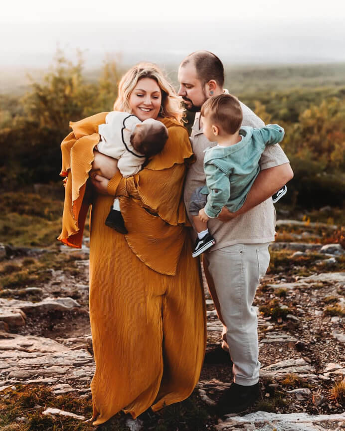 A mother and father holding their daughter and son during sunset on a mountain in Sussex County, New Jersey.