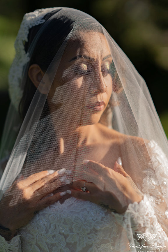 Bride under a netted veil outdoors