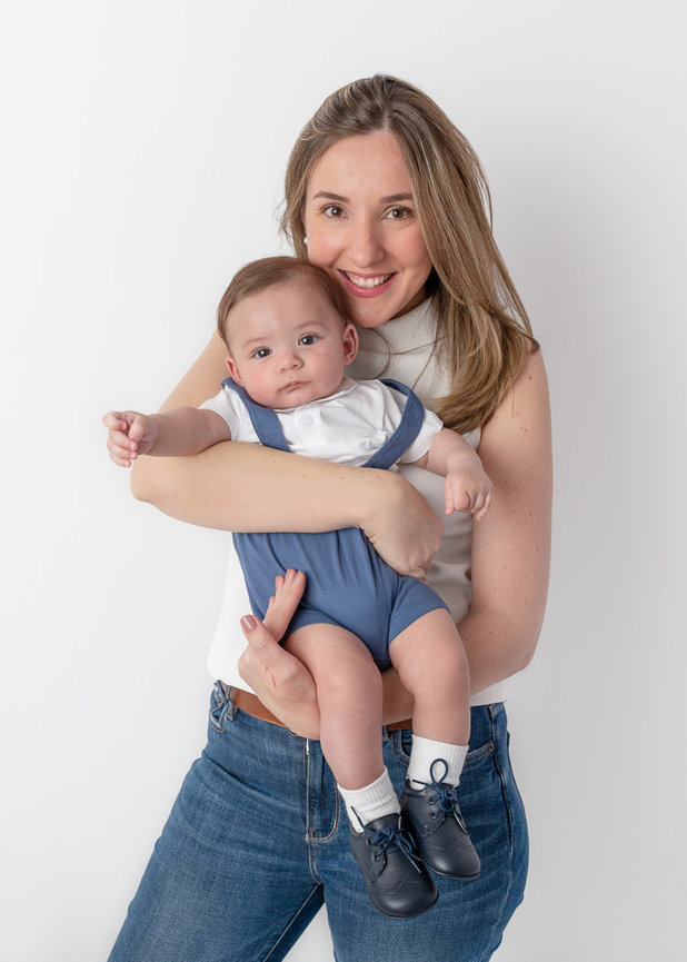 Mother is smiling and holding her toddler next to her face