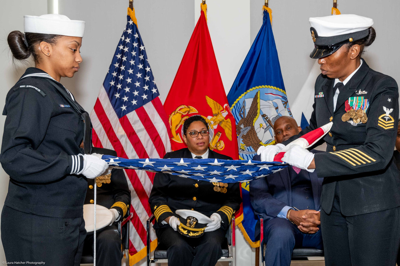 Two Navy Sailors performing a flag folding ceremony during a retirement ceremony