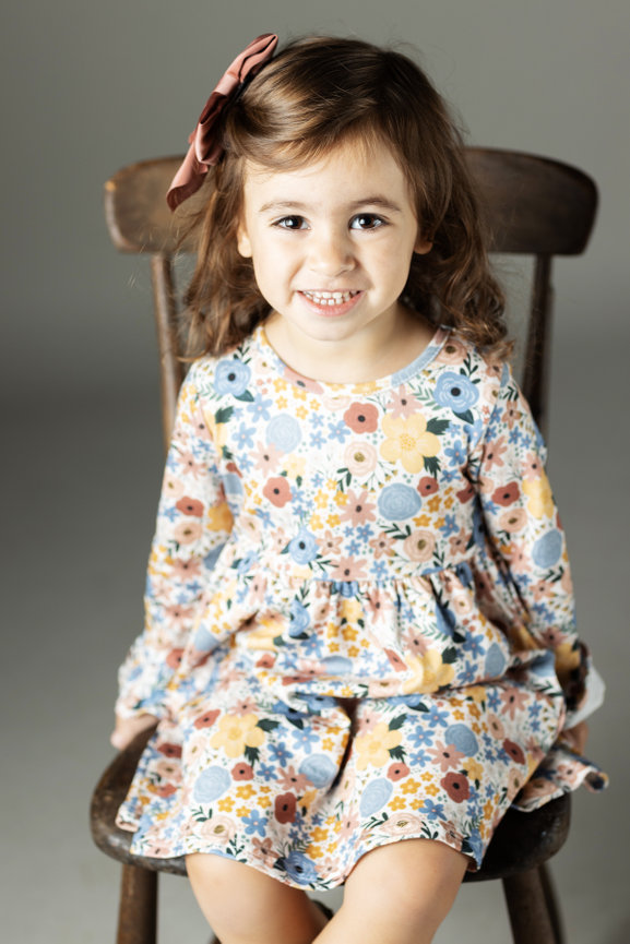 Girl in a floral dress on a chair