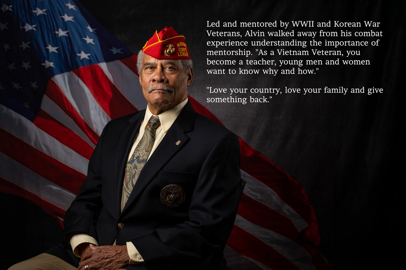 Portrait of a Marine Corps veteran in a red cap with an American flag background and biographical text