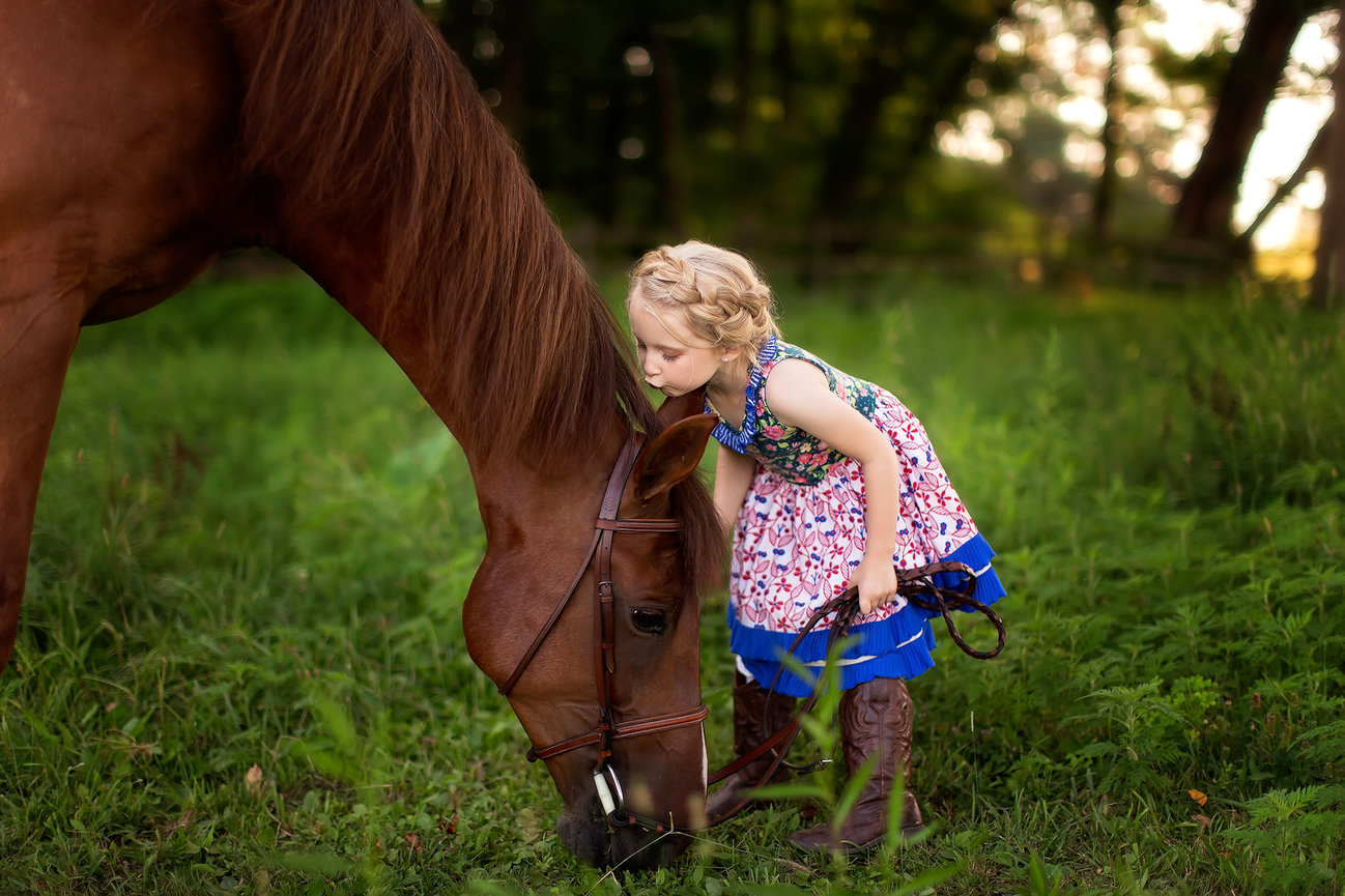 Young girl kissing her horse during an outdoor child portrait session near Wooster, Ohio.