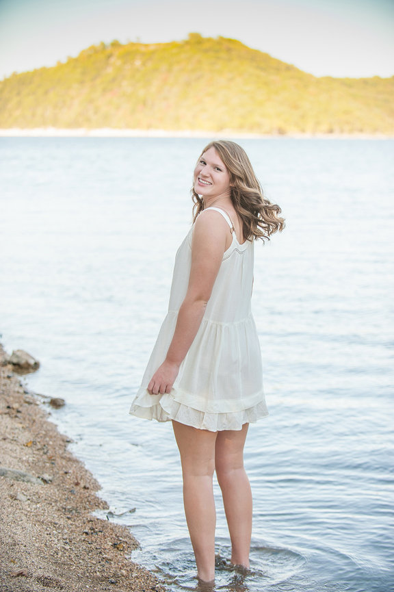 Senior girl in white dress posing for senior portrait at Table Rock Lake Branson. 