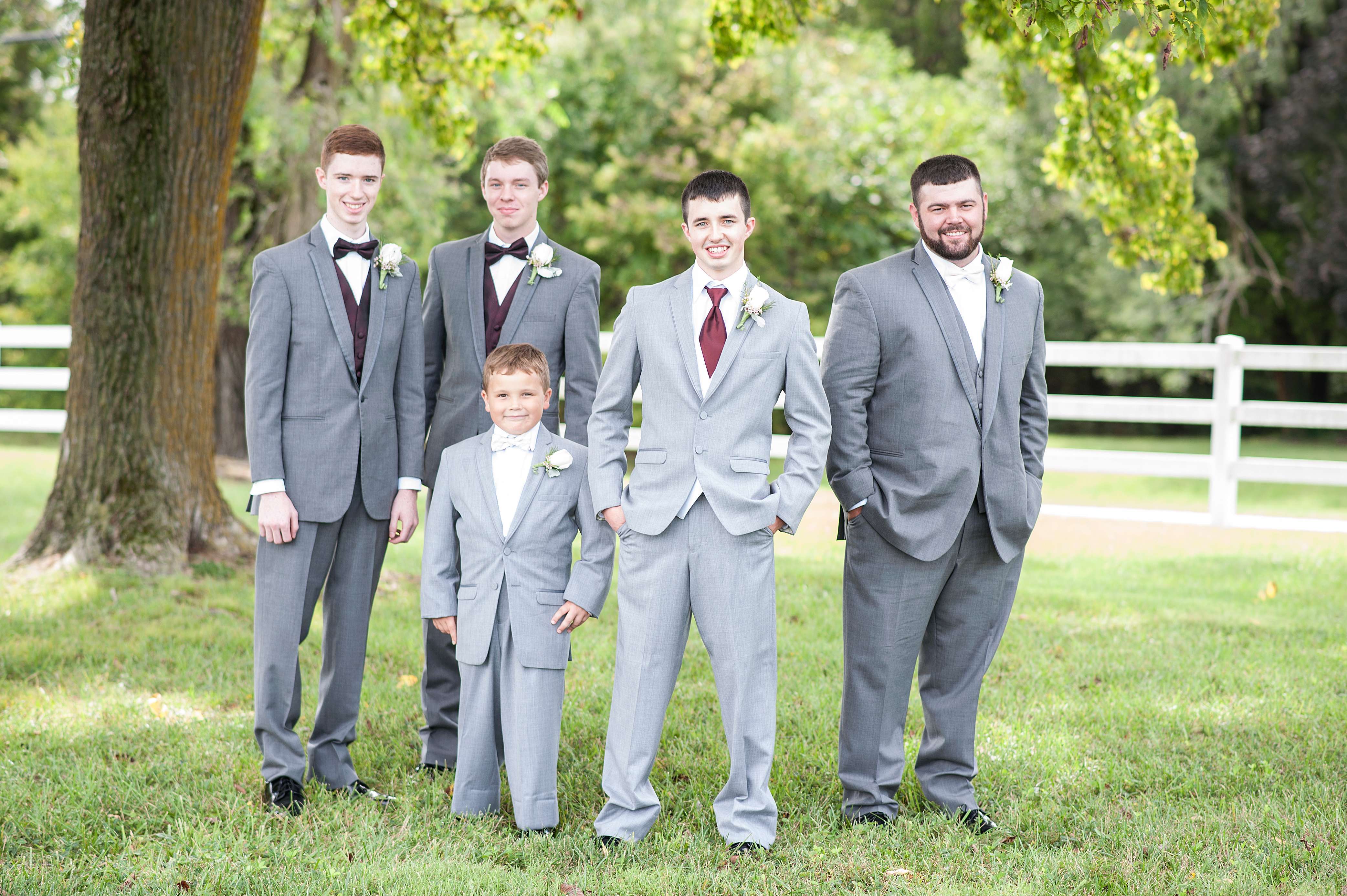 Groom posing for photo with groomsmen.