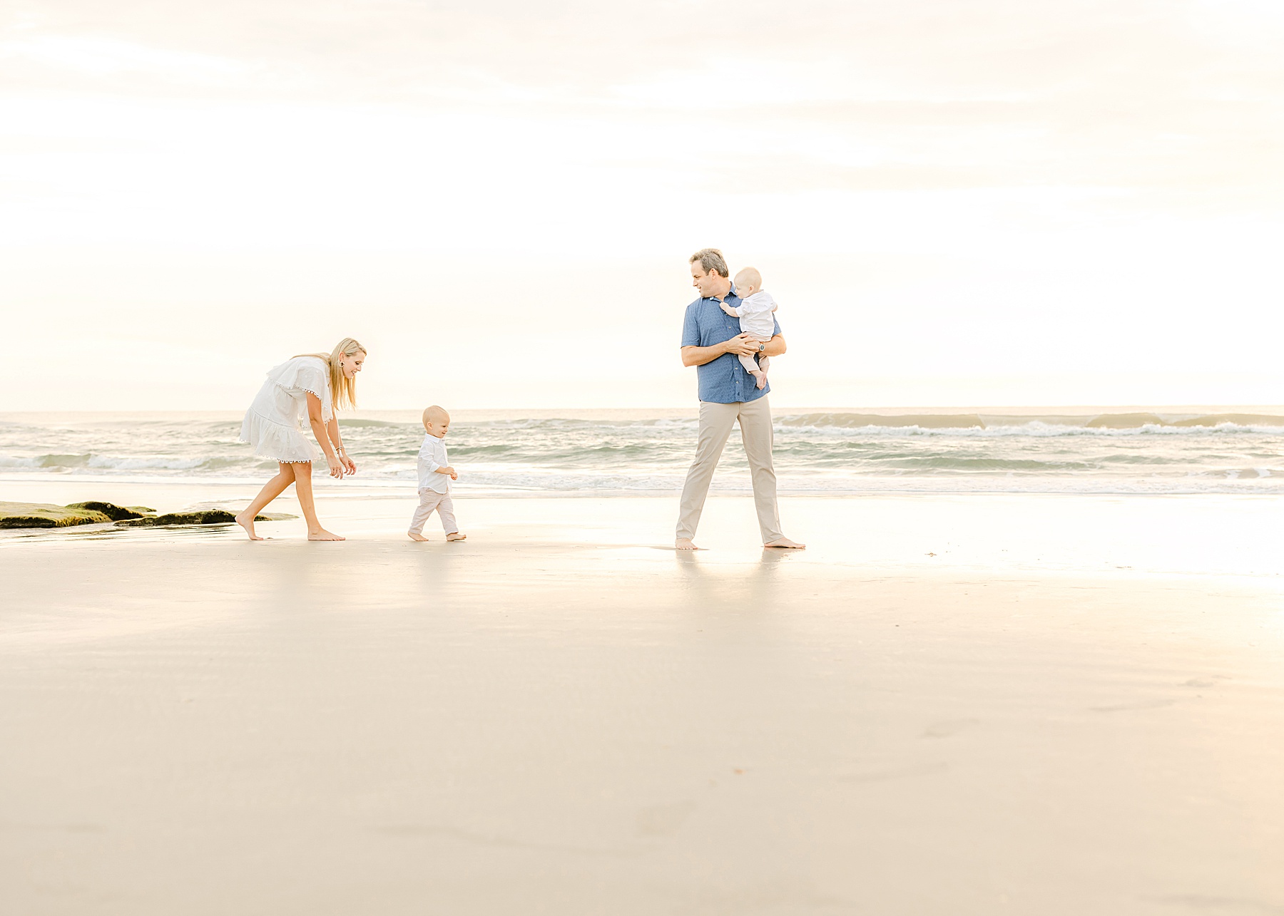 family chasing baby boys on the beach at sunrise in st. augustine florida