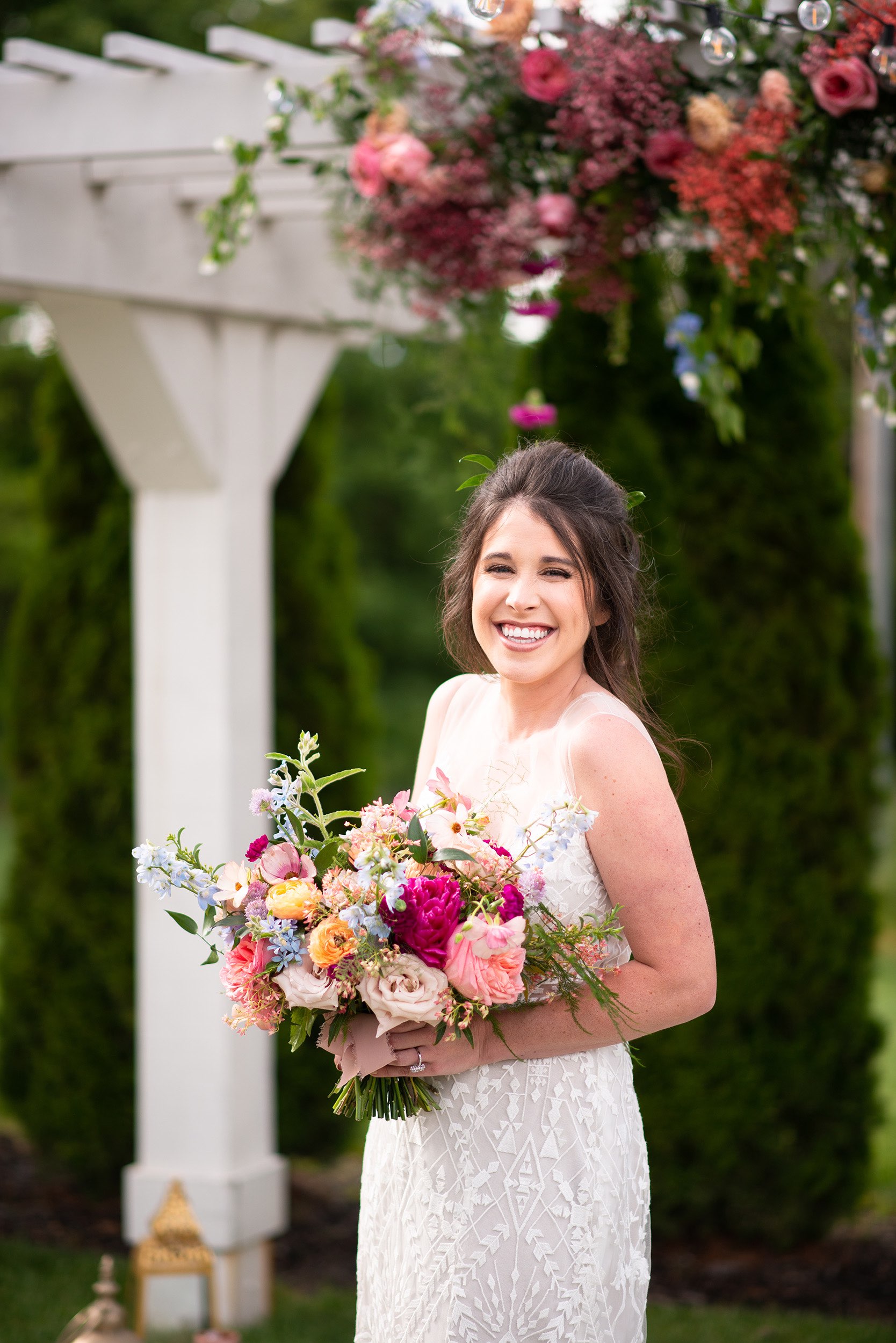 Smiling bride with colorful bouquet.