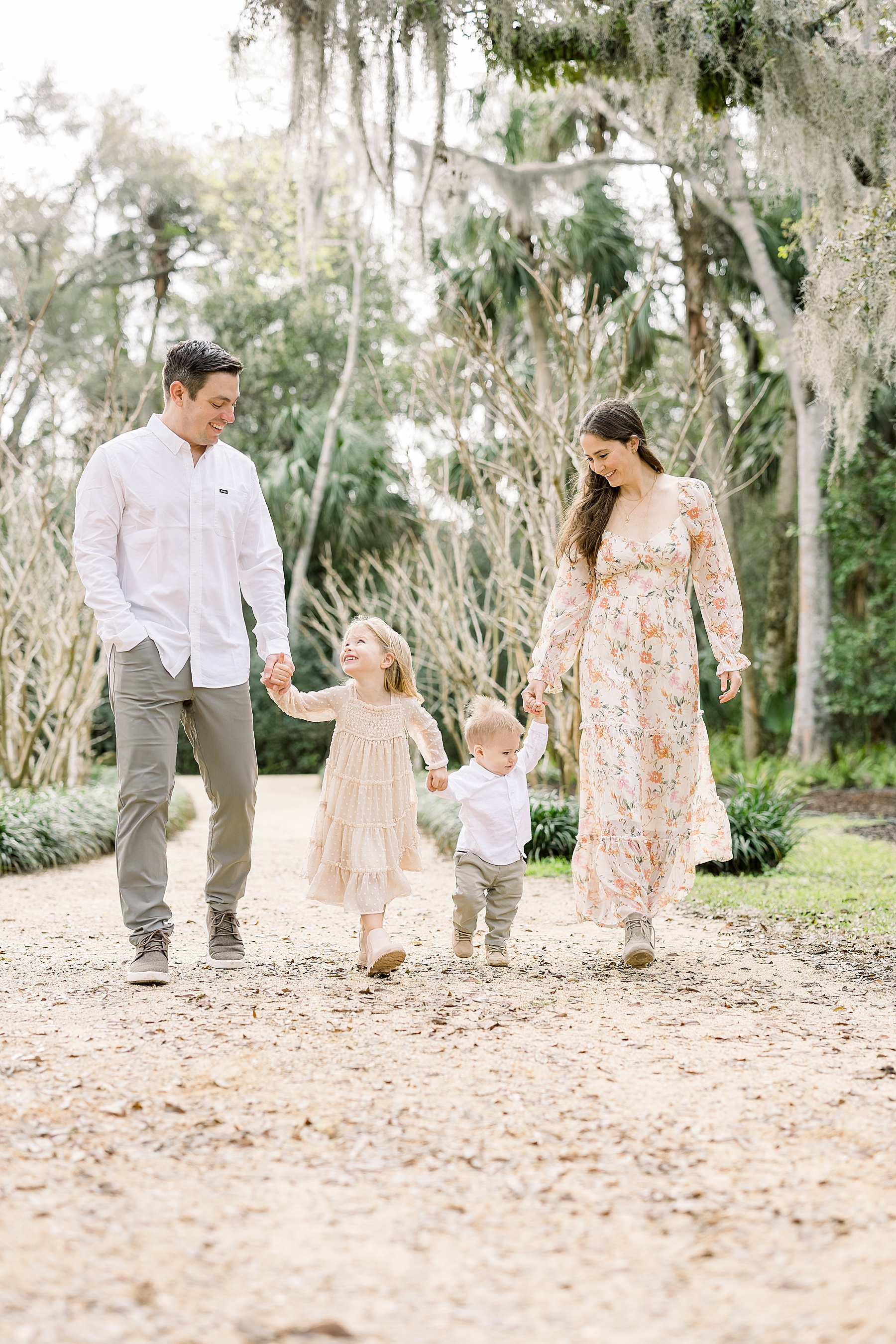 family walking holding hands in the spring at Washington Oaks Gardens State Park