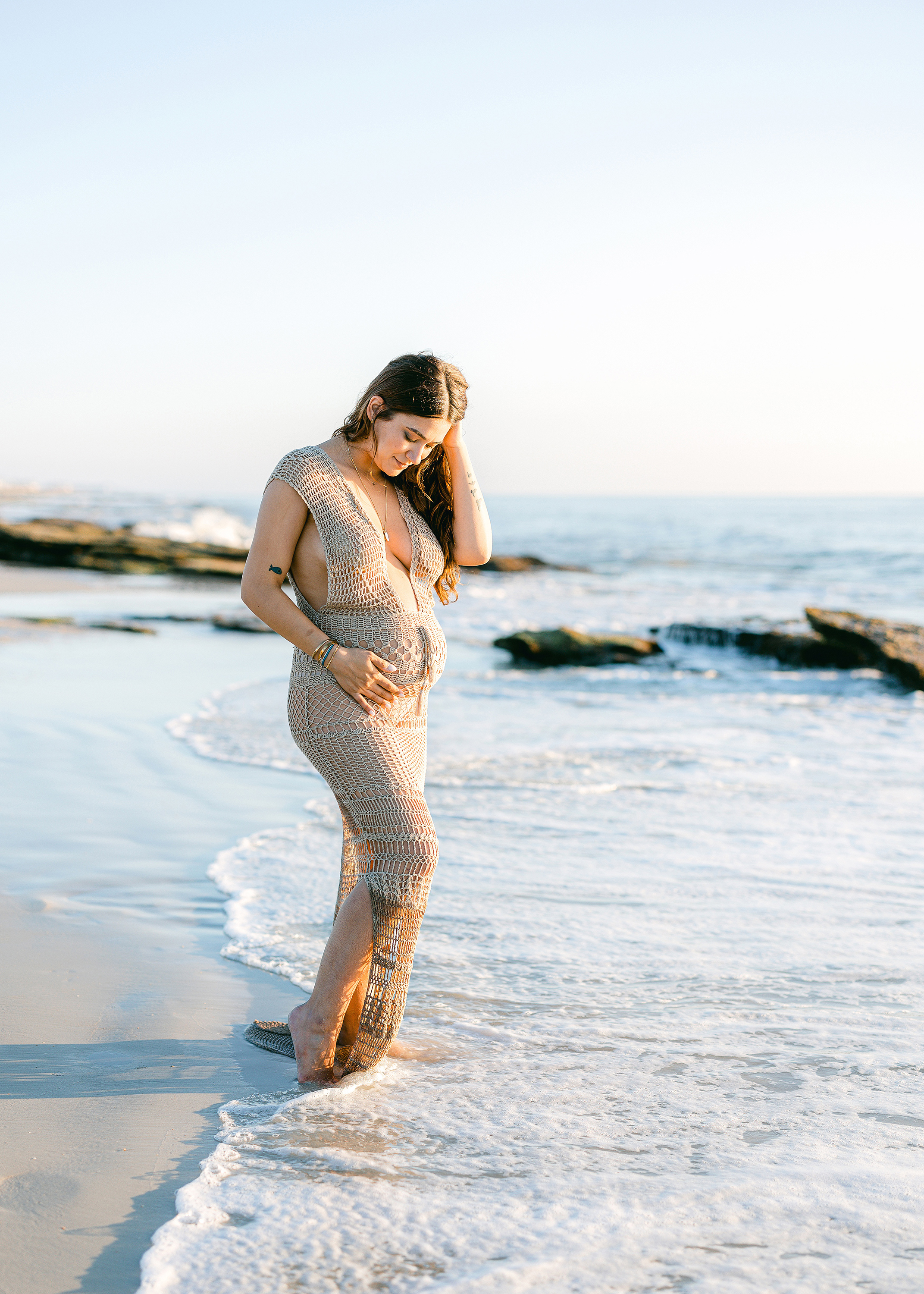 sunrise pregnancy portrait of woman standing in the surf on Saint Augustine Beach