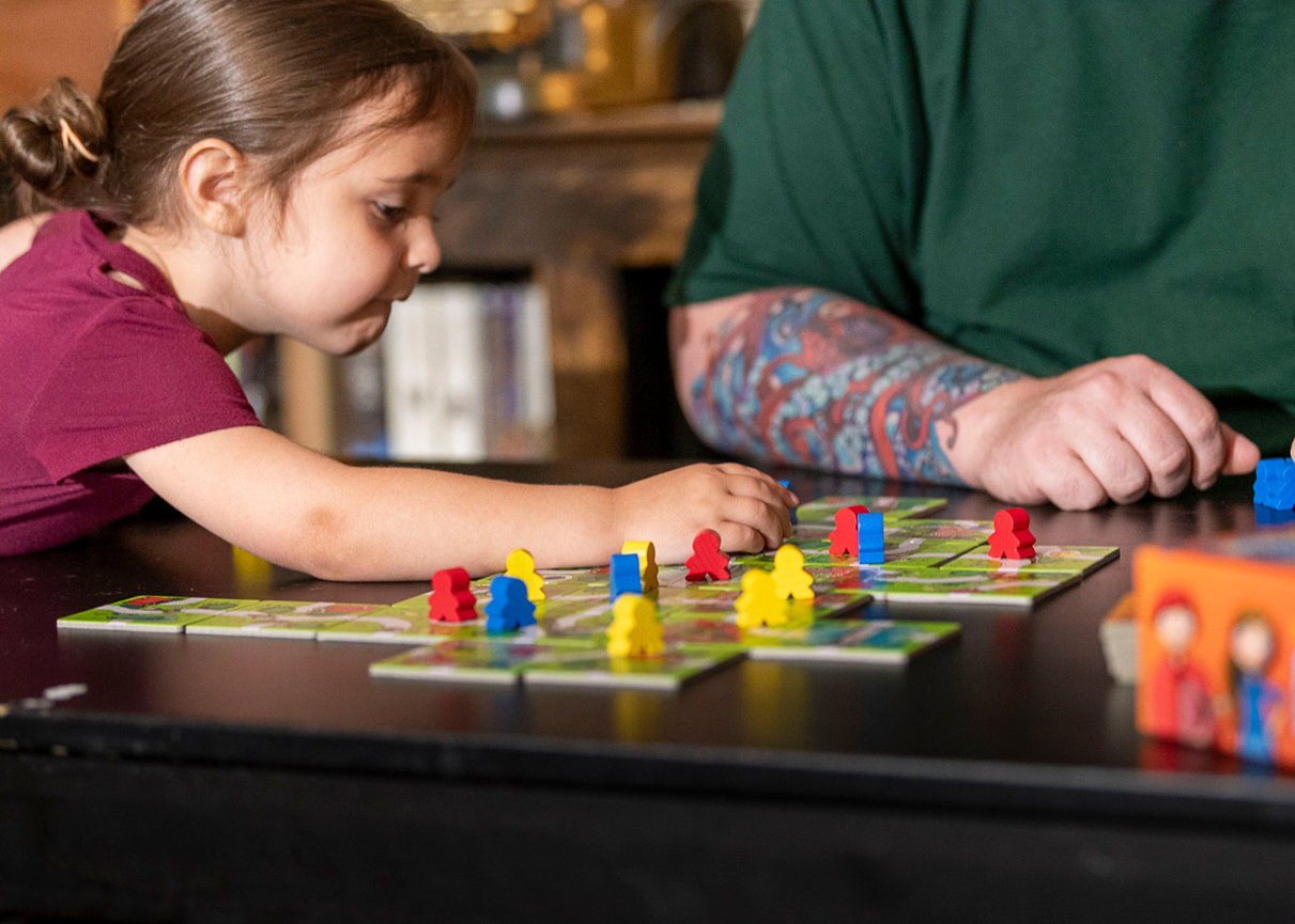 A daughter and dad playing a board game.
