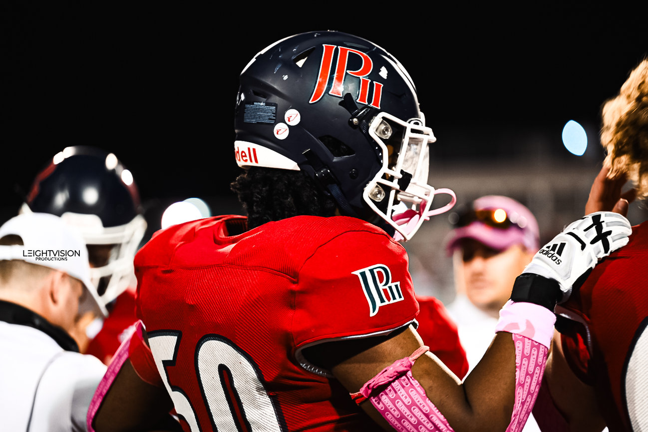 A football player is seen discussing tactics with another player, emphasizing teamwork and communication in the sport.