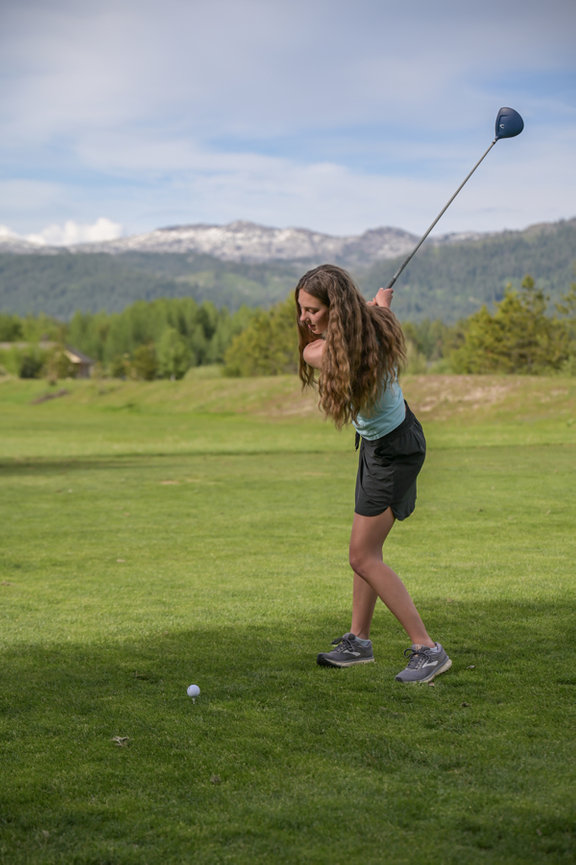 Senior year girl hitting golf ball. McCall, Idaho