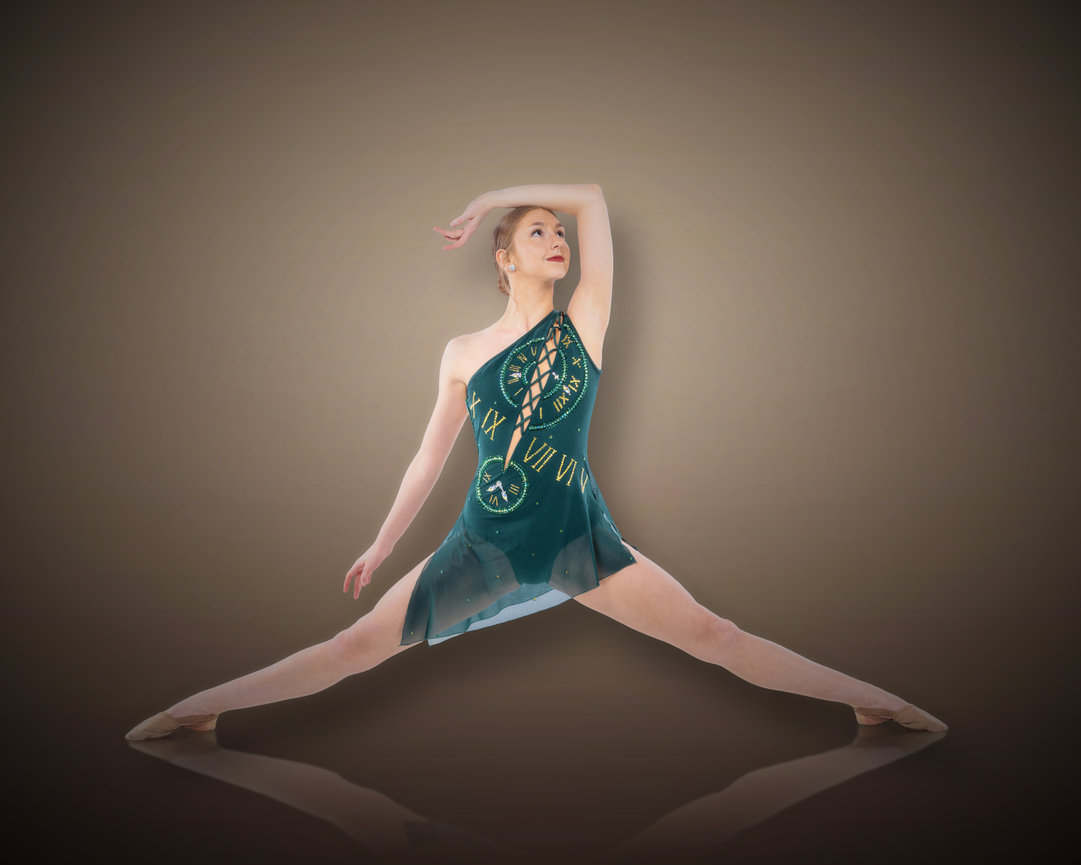 Ballet dancer in a split pose wearing a green costume against a gradient brown background.