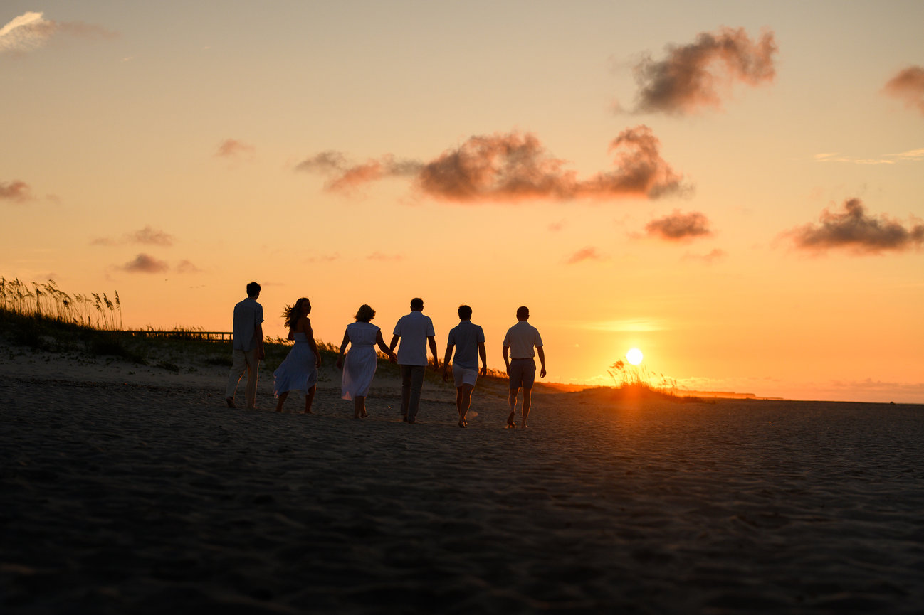 silhouettes of a family of six walking off into the sunrise