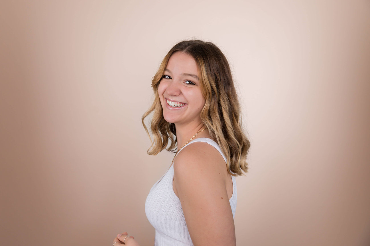 Smiling woman in white tank top, profile view