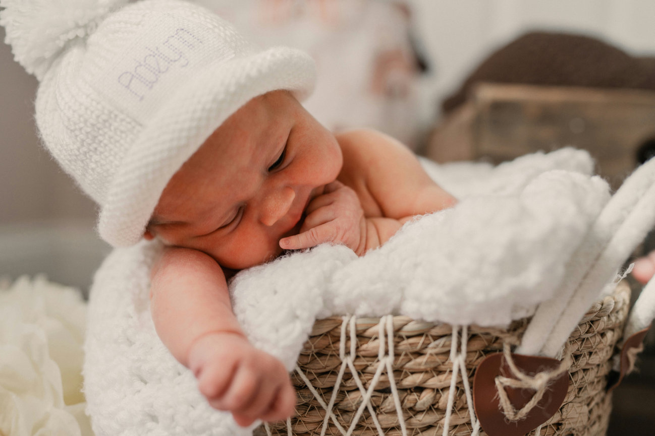 Sleeping newborn baby nestled in a woven basket