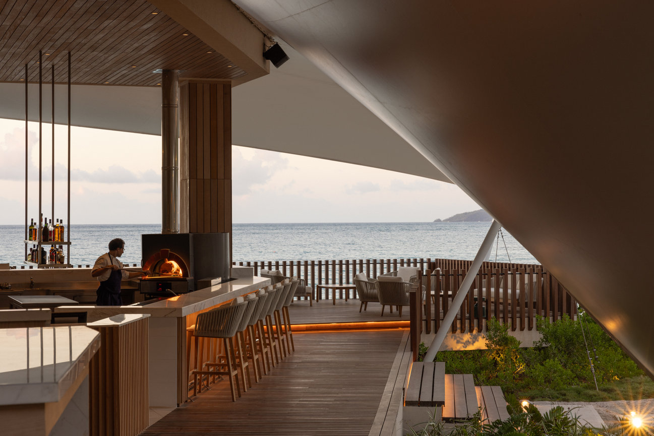 Restaurant at Silversands Beach house covered by large tents showing all wood interiors pizza ovens and outdoor terrace on the ocean.
