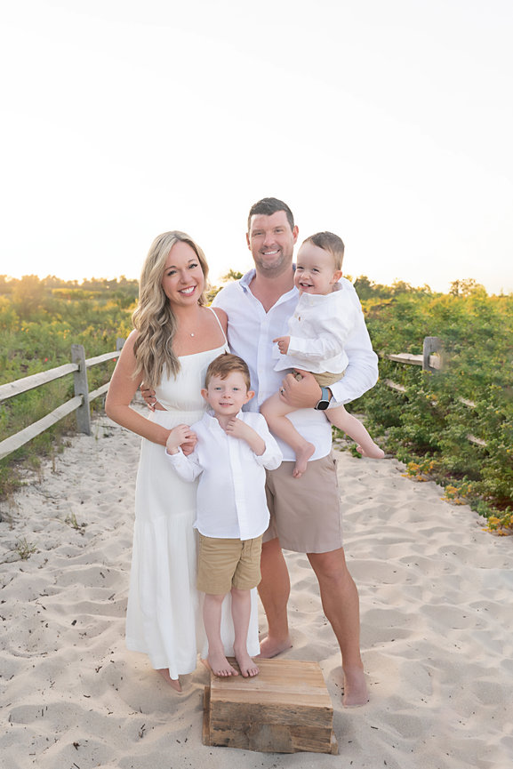 Perfectly posed family smiling directly at camera with natural light