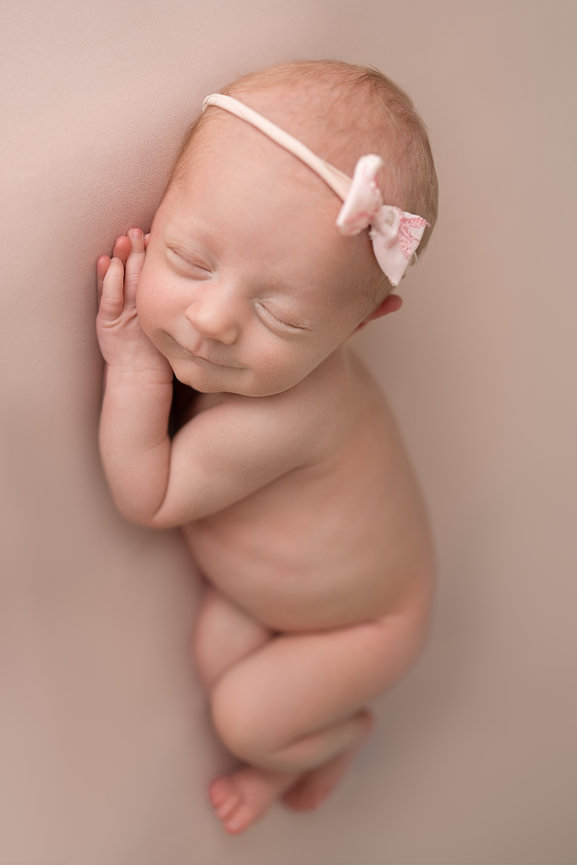 Minimalist newborn image with baby posed on smooth blush pink backdrop in Sea Girt portrait studio