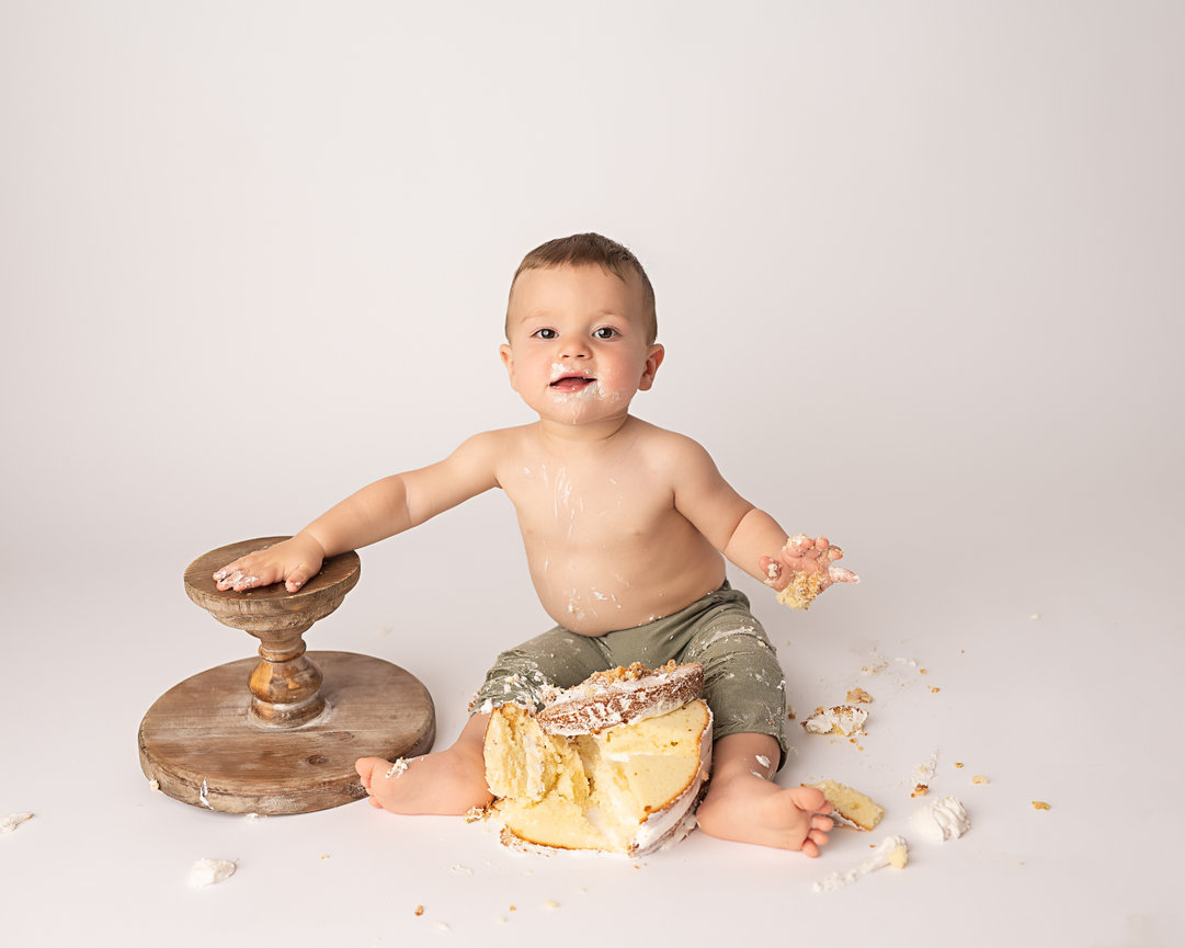 Messy cake smash with baby joyfully covered in icing