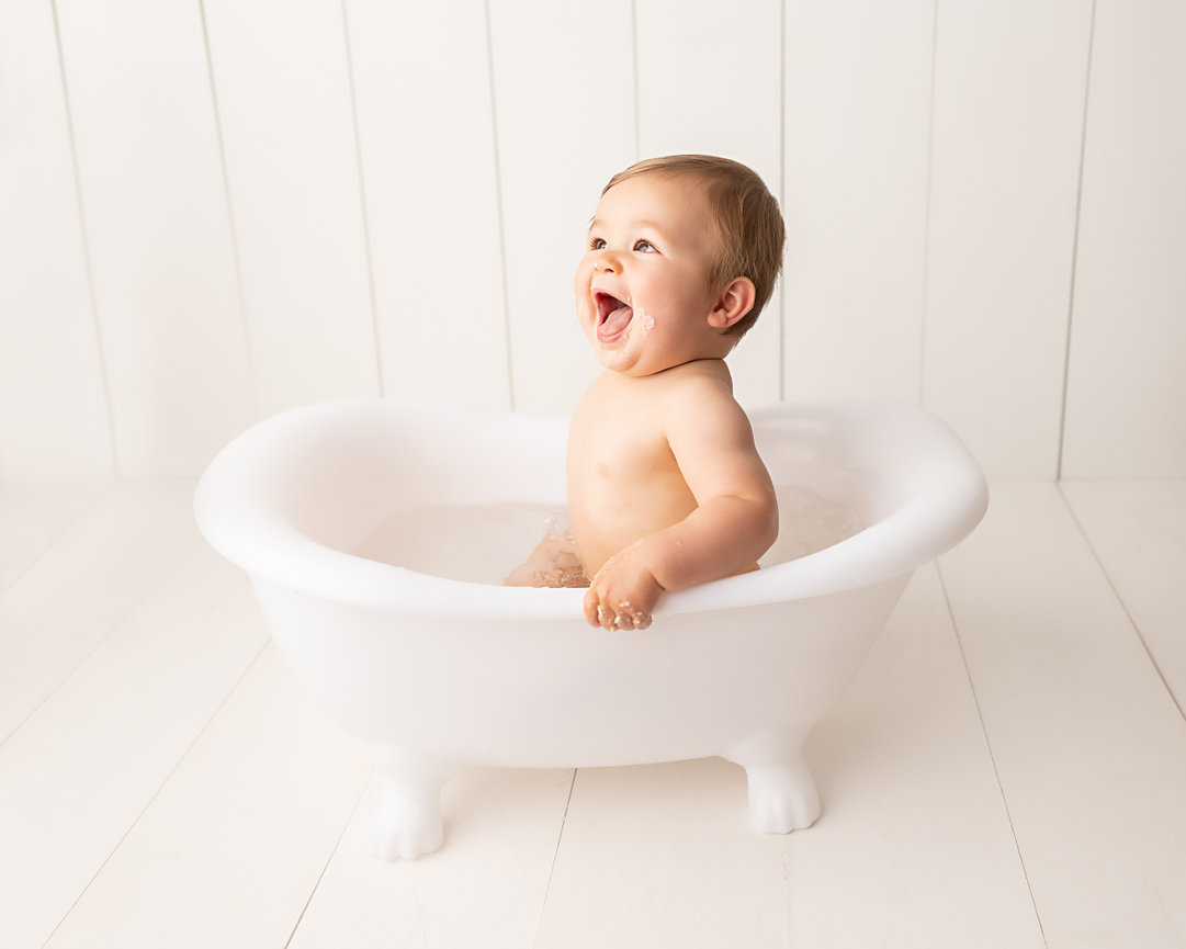 Joyful baby in Scotch Plains photoshoot, splashing water during cake smash cleanup photos