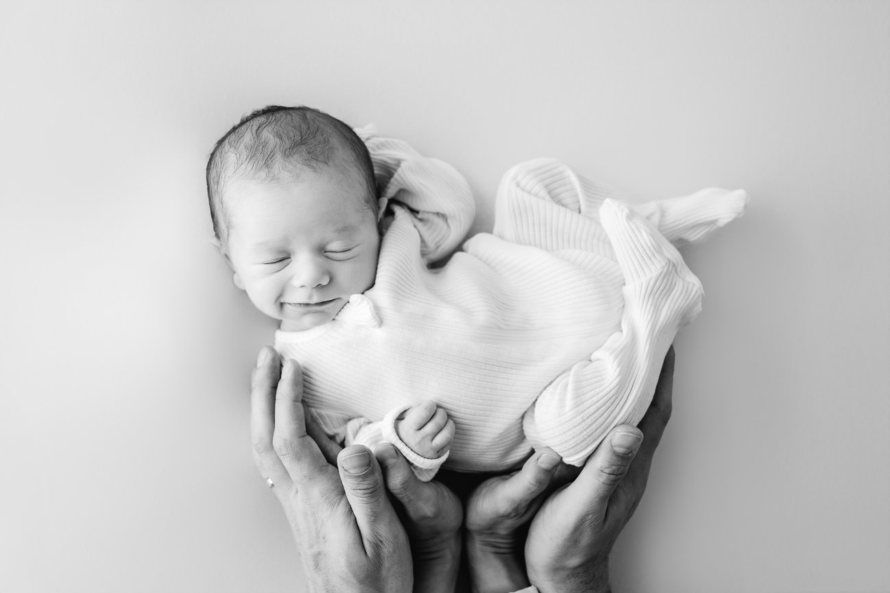 Newborn lying peacefully on white backdrop in Kristin Baker’s Manasquan, NJ studio