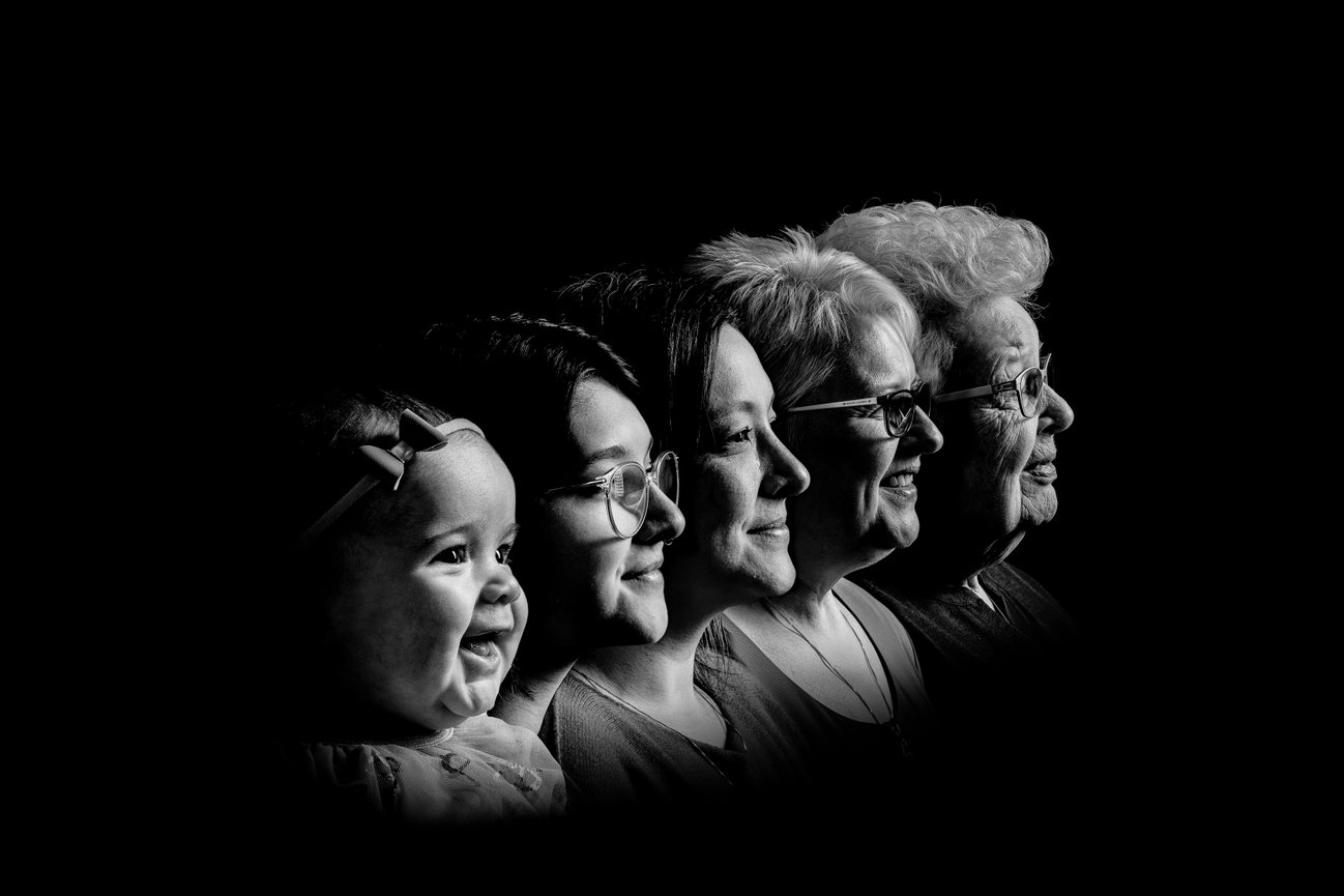 Five women from different generations in profile, facing right against a black background.