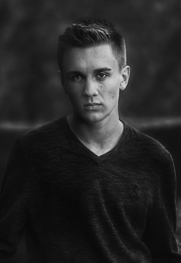 Black and white portrait of a young man looking at the camera.