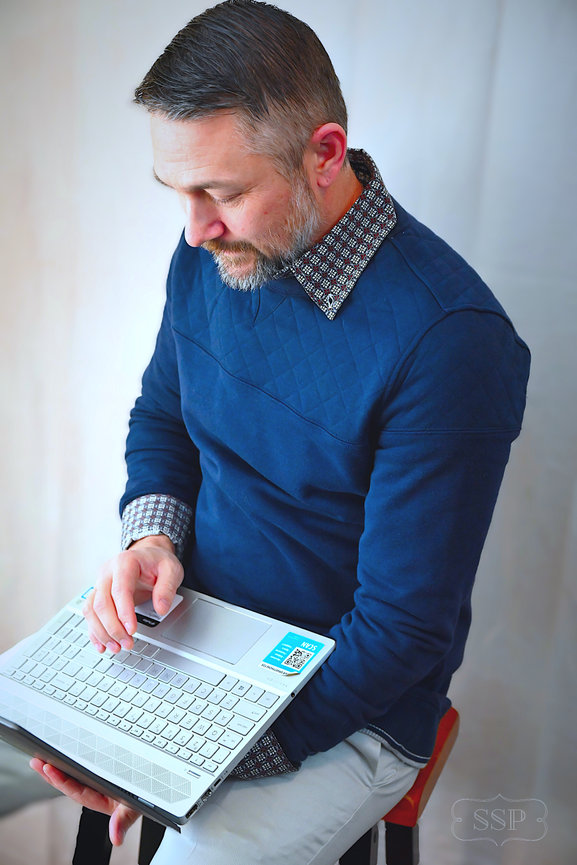 Man reading a book while seated in a bright indoor portrait