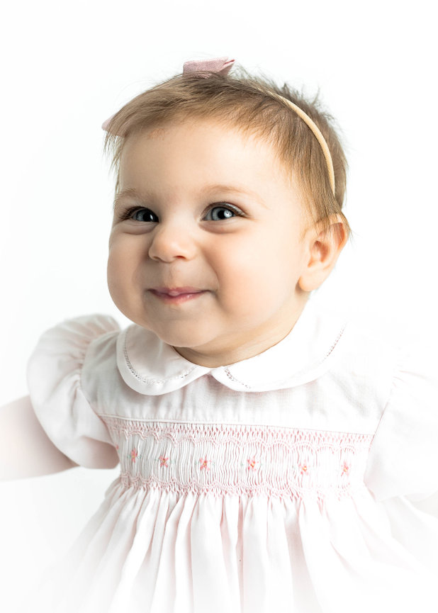 Classic heirloom portrait of baby in vintage-style outfit with soft lighting