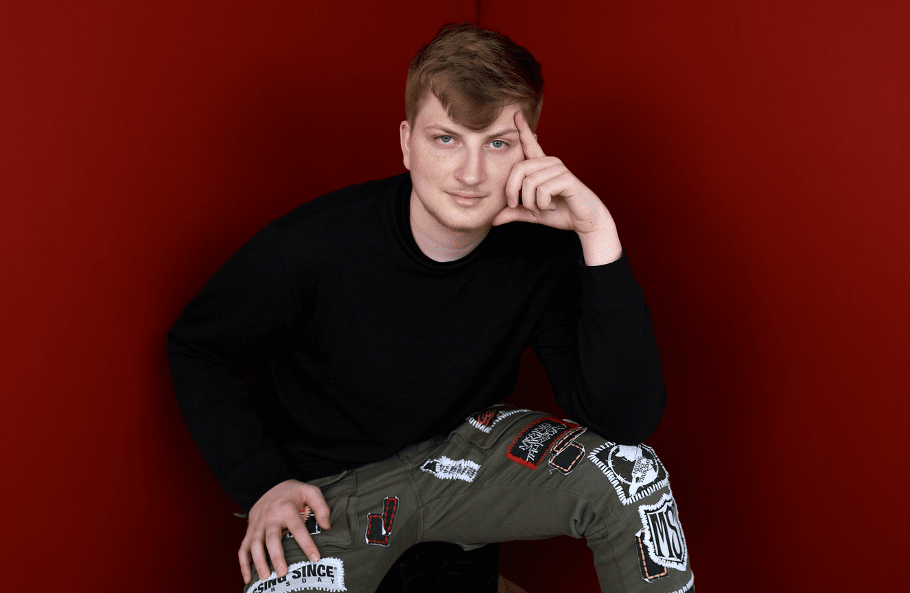 A young man wearing artisan made patch work pants to his senior photo session at Kliks Photography in Cedar Rapids, Iowa.