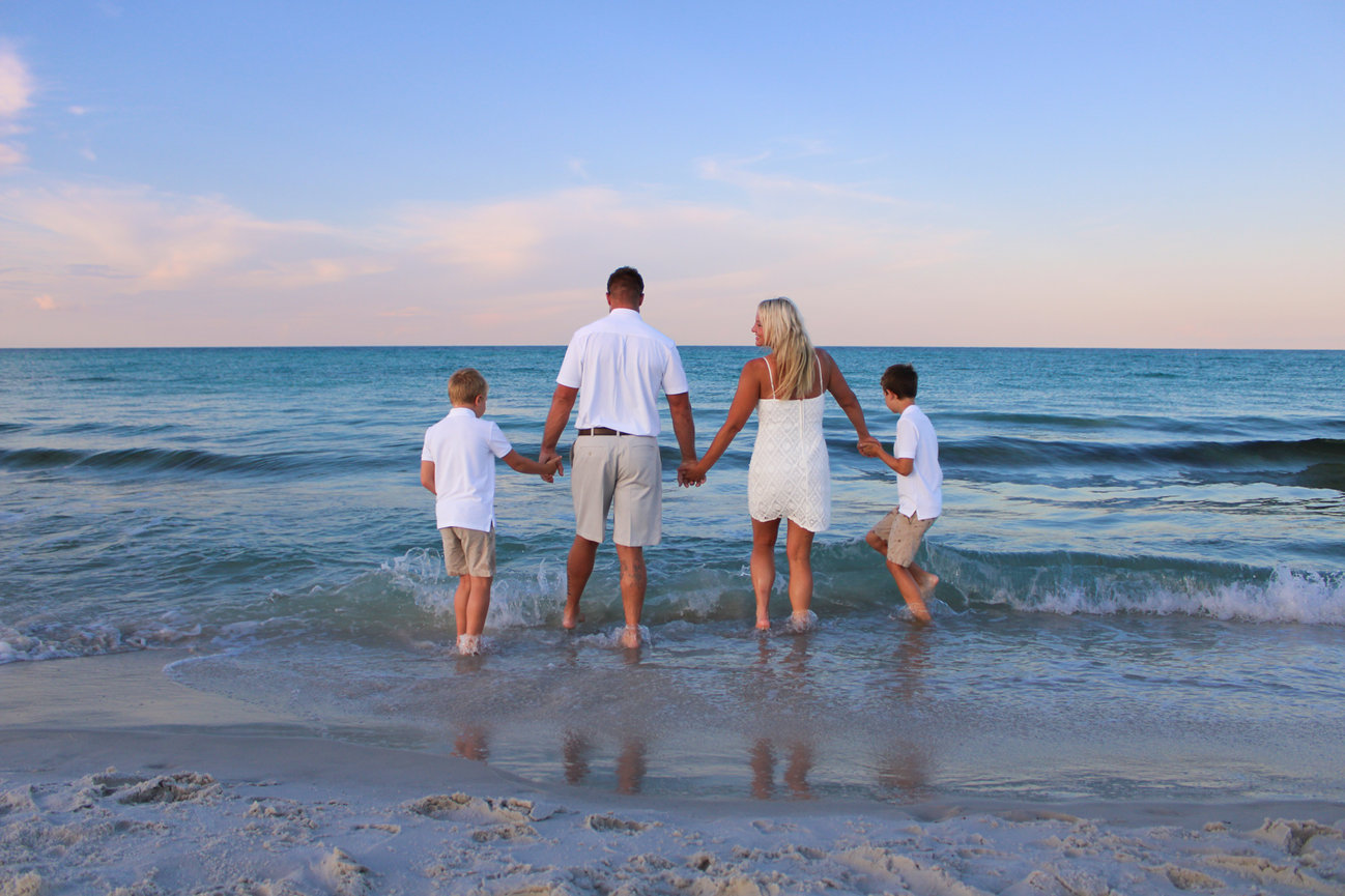 A family of four walking into the ocean together