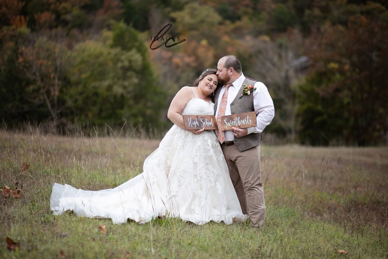 Bride and groom sharing an embrace in a grassy field